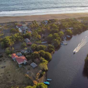The image depicts a serene scene of a river with a boat, surrounded by lush greenery and a clear sky, evoking a sense of tranquility and natural beauty.