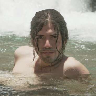 The image depicts a man with long, wet hair, submerged in water, with a subtle watermark featuring the text \"workaway.info\" in the center of the frame.