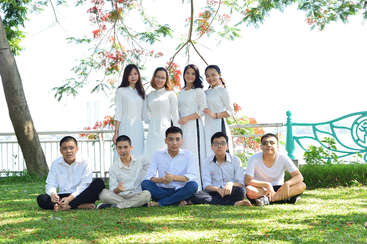 The image depicts a group of individuals, likely friends or family members, posing for a photo, showcasing their diverse attire and hairstyles, with a mix of casual and formal clothing.