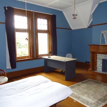 The image depicts a serene room with blue walls, a large window, a desk, and a fireplace, exuding a sense of calmness and tranquility.