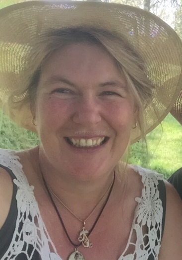 The image depicts a woman wearing a straw hat and a white lace top, with a serene grassy background. The woman\'s attire and surroundings convey a sense of casual elegance.